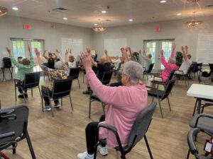 Senior adults in an assisted living community in the Northshore performing chair exercises