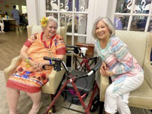 Two senior adult women dressed for a Luau at The Windsor Senior Living Community