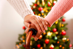 A woman holds a senior woman's hand during Christmas. 