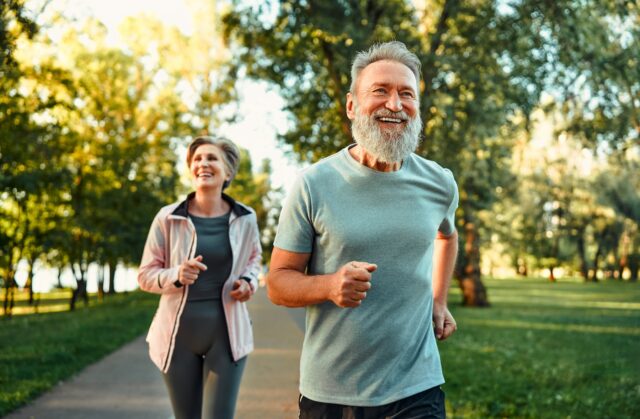Cheerful husband and wife competing together and jogging on fresh air.